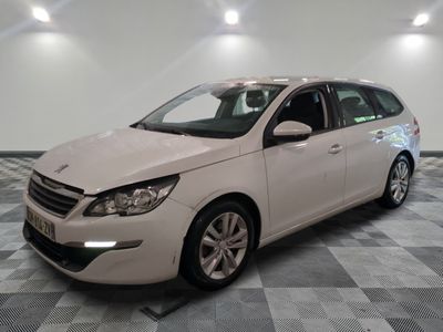 la voiture blanche est garée sur un sol en damier dans le garage