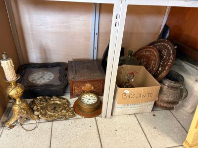 une étagère sur laquelle se trouvent une horloge, une boîte dorée, une autre horloge et d'autres objets