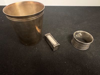un seau en argent et un rasoir posés sur une table noire