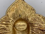 an image of a gold plate with a flower on it
