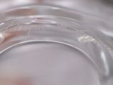 a close up of a glass of water with a red flower in it