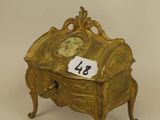 a gold box with a clock on top of it