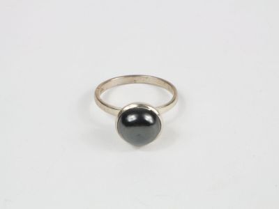 une bague en argent avec une pierre noire au centre