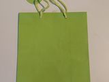 un sac en papier vert muni d'une ficelle