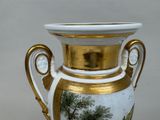a vase with a painting on it sitting on a table