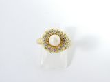une image d'une bague en perles et diamants sur une surface blanche