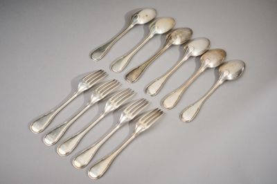 six silverplated spoons and six forks on a white surface