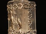 a glass bottle with a silver lid sitting on a table