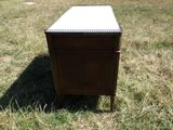 une petite table avec un plateau en marbre posée dans l'herbe