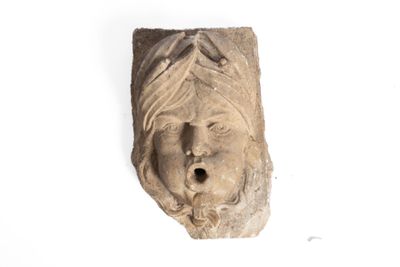 une sculpture en pierre représentant le visage d'une femme sur une surface blanche
