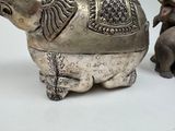 two elephant figurines sitting next to each other on a table