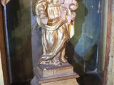 a statue of a woman holding a child in a glass case
