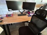 un bureau sur lequel sont posés deux écrans d'ordinateur, avec une chaise devant