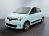 La voiture bleu clair est garée dans une pièce au sol noir.