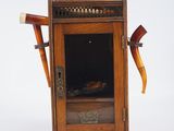 une petite armoire en bois sur laquelle est posé un chapeau