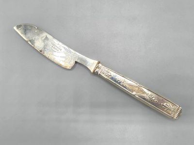 a close up of a knife on a table with a gray background