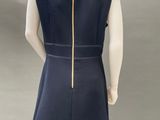the back view of a mannequin wearing a blue dress with gold zippers