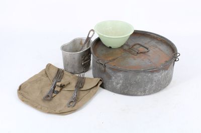 a metal pan with a green bowl and utensils next to it