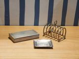 a silver plate and a silver card holder on a wooden table