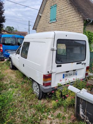 une camionnette blanche garée devant une maison