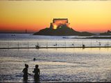 two people that are standing in the water at the beach