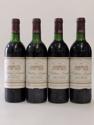 four bottles of wine are lined up on a white surface