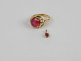 a close up of a ring with a red stone in it