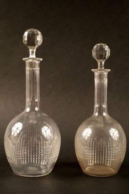 trois bouteilles en verre posées sur une table, sur fond noir