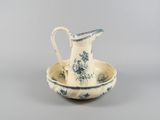 a blue and white pitcher and bowl sitting on a table