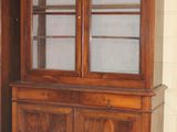 a large wooden cabinet with glass doors in a room