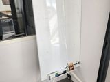 a white board on a tripod in the corner of a room