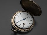 une montre de poche en argent posée sur une table