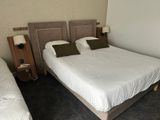 two beds in a hotel room with white sheets on them