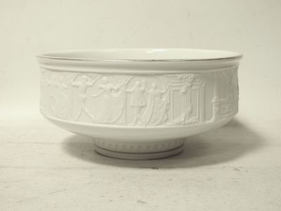 un bol blanc posé sur une table, avec un mur blanc en arrière-plan
