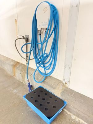 a blue hose on the ground next to a blue box