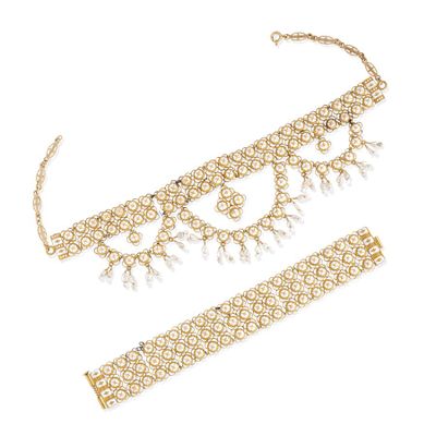 a gold necklace and bracelet set with pearls on a white background
