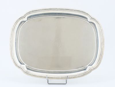 un plateau en argent ancien posé sur un support, avec un miroir au centre