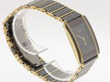 an image of a black and gold watch on a white surface