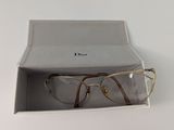 Des lunettes Christian Dior dans un étui posé sur une surface blanche