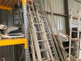 many ladders stacked up in a warehouse area
