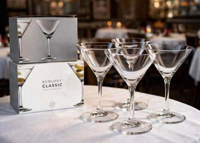 quatre verres à vin posés sur une table sur laquelle se trouve une boîte