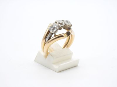 gros plan d'une bague en or et diamants sur une surface blanche