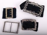 three pieces of black velvet and silver metal buckles on a white surface
