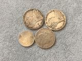 three british coins sitting on top of each other on a gray surface