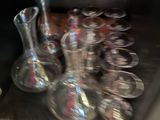 bottles and glasses on a shelf in a room with a wooden floor