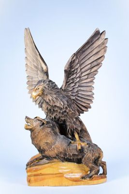 statue représentant un aigle et un ours sur un rocher, avec le ciel en arrière-plan