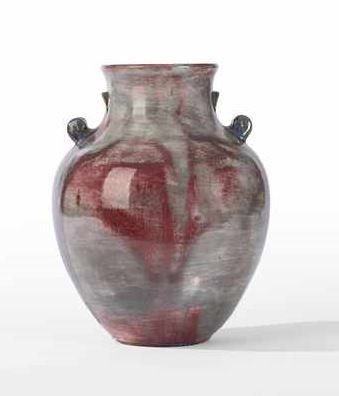 un vase rouge posé sur une surface blanche, avec un fond blanc
