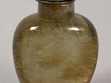 a glass vase with a red lid sitting on a table