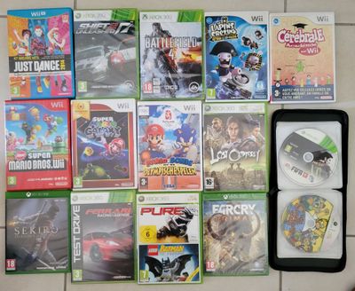 a lot of video games on the floor next to a cell phone