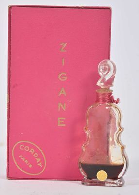 une image représentant un flacon de parfum posé à côté d'une boîte rose